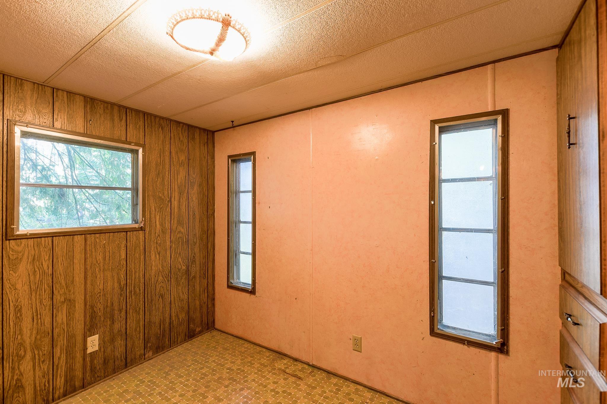 1206 Idlers Rest Road Moscow, ID 83843 - Photo 24 of 47 Interior room featuring wood paneling, multiple windows, and patterned flooring