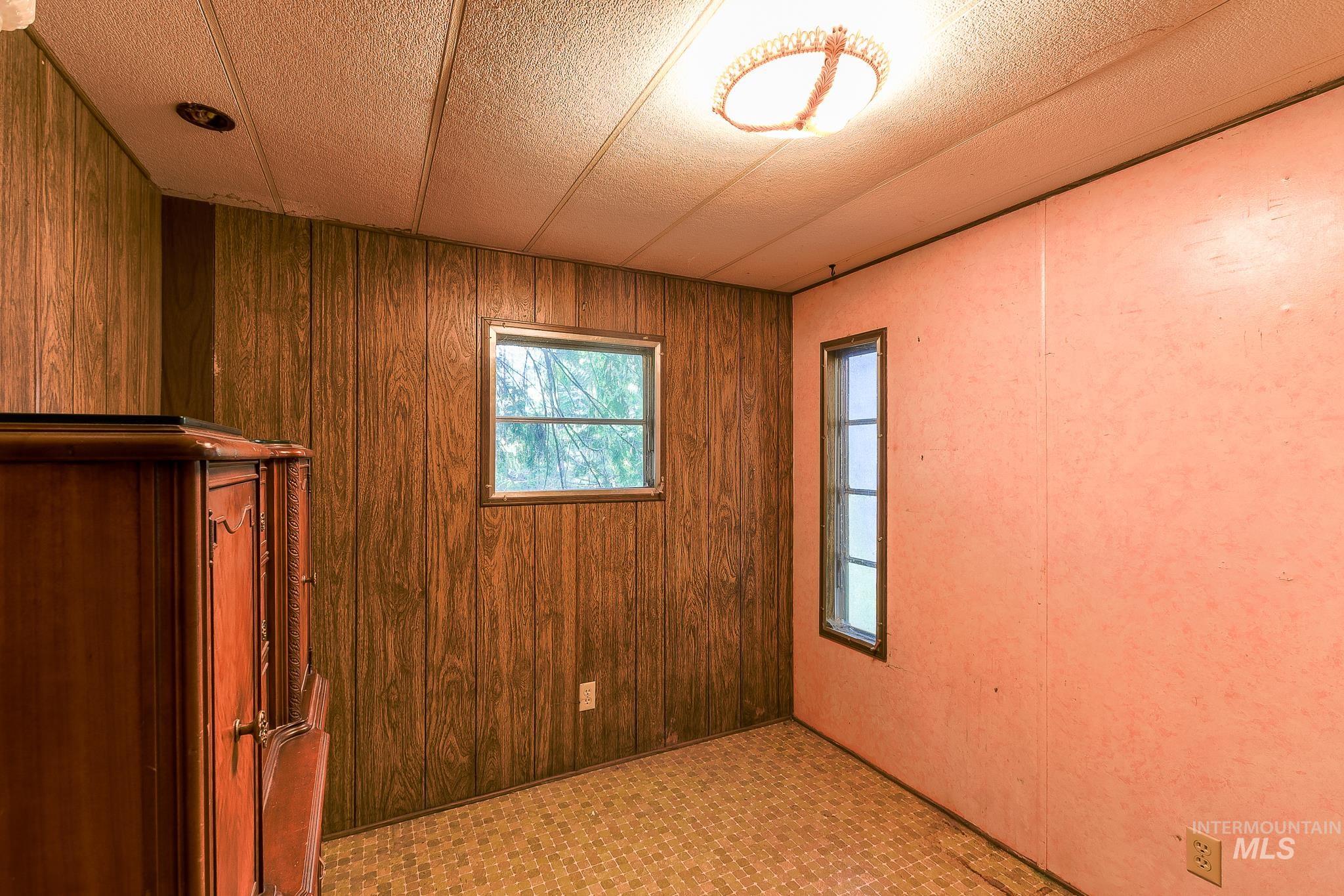 1206 Idlers Rest Road Moscow, ID 83843 - Photo 25 of 47 Interior space featuring paneling and light-colored walls, a ceiling-mounted light fixture, and two windows providing natural light