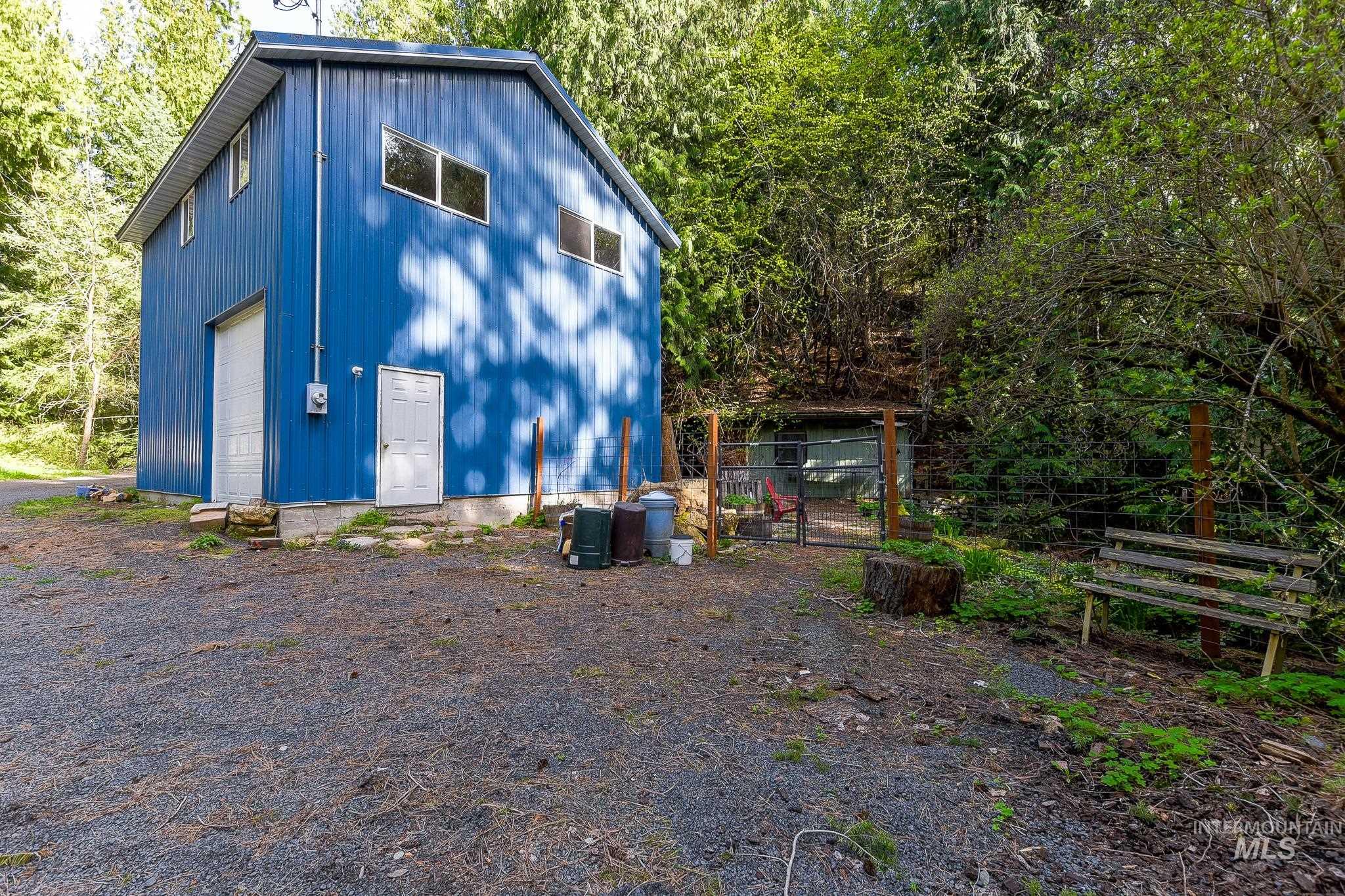 1206 Idlers Rest Road Moscow, ID 83843 - Photo 26 of 47 Two-story blue metal-sided structure featuring a single garage door, a pedestrian door, and multiple windows