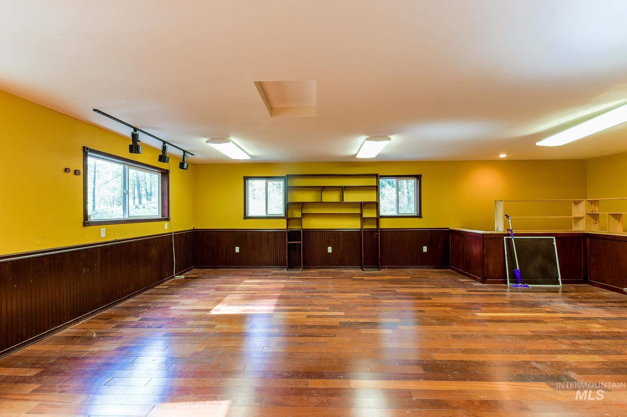 1206 Idlers Rest Road Moscow, ID 83843 - Photo 35 of 47 Spacious room featuring wood-finish flooring, multiple windows, built-in shelving, track lighting, and recessed lighting