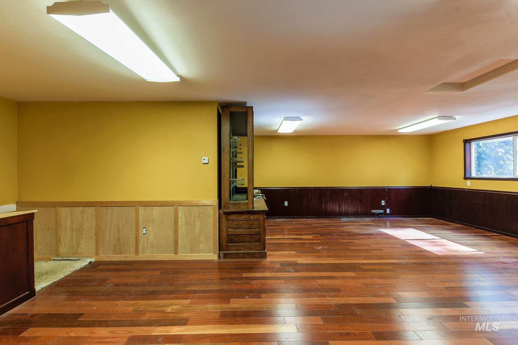 1206 Idlers Rest Road Moscow, ID 83843 - Photo 37 of 47 Spacious interior featuring wood-finish flooring, two-tone wall paneling, and a built-in wood display cabinet