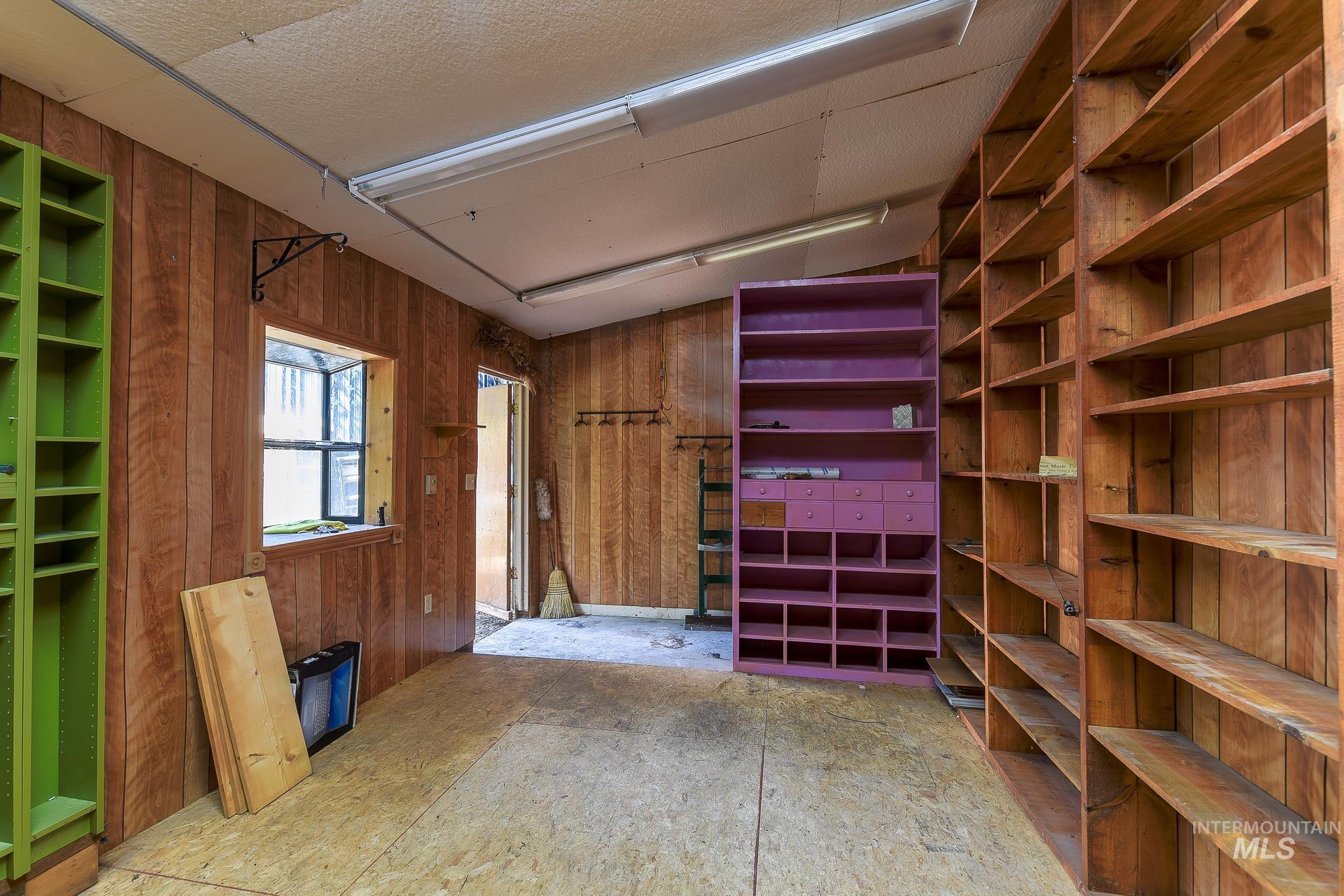 1206 Idlers Rest Road Moscow, ID 83843 - Photo 44 of 47 Room featuring extensive built-in shelving, wood-paneled walls, and a window providing natural light