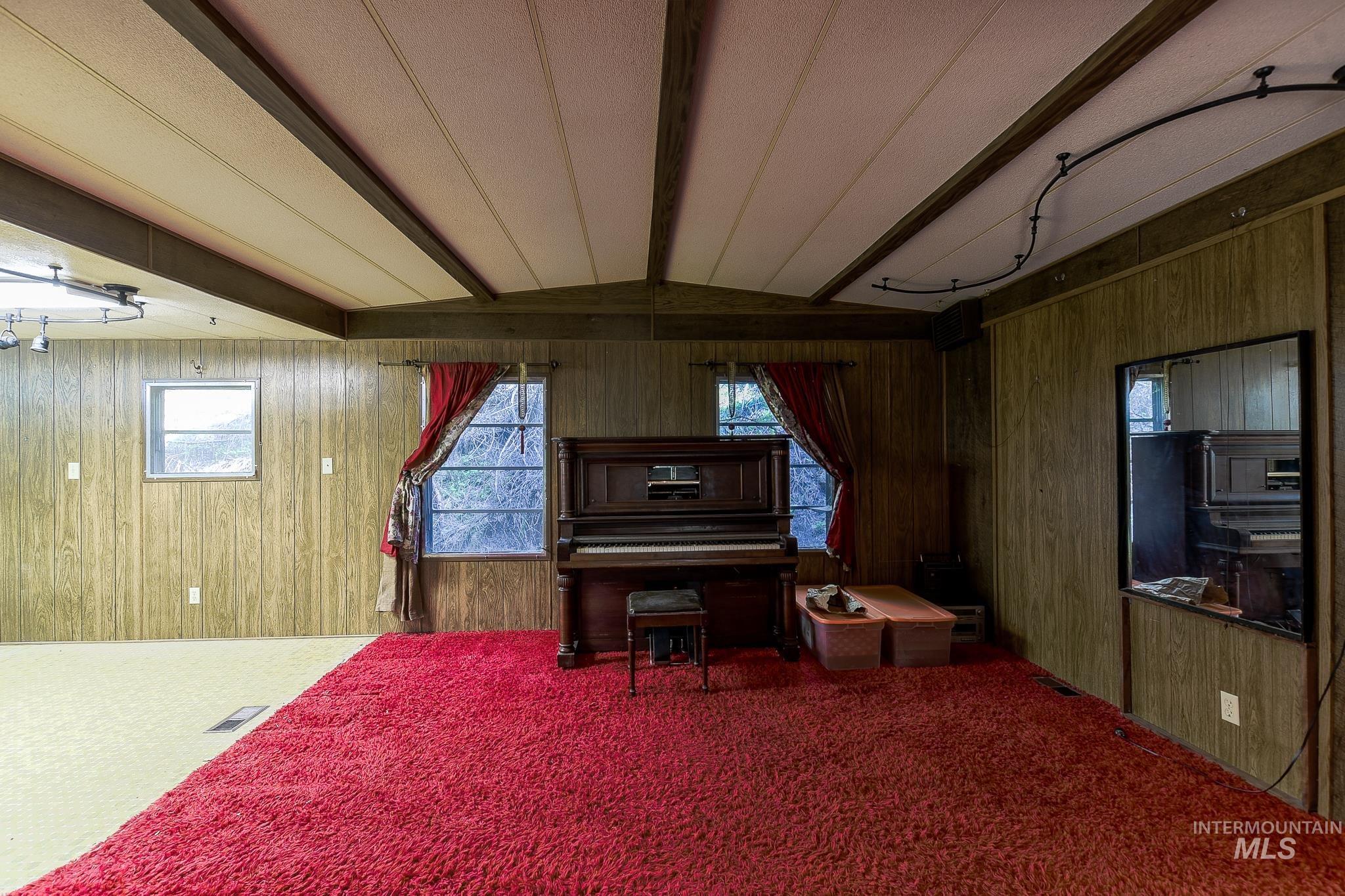 1206 Idlers Rest Road Moscow, ID 83843 - Photo 6 of 47 Spacious room featuring wood paneling, a ceiling with exposed beams, and track lighting
