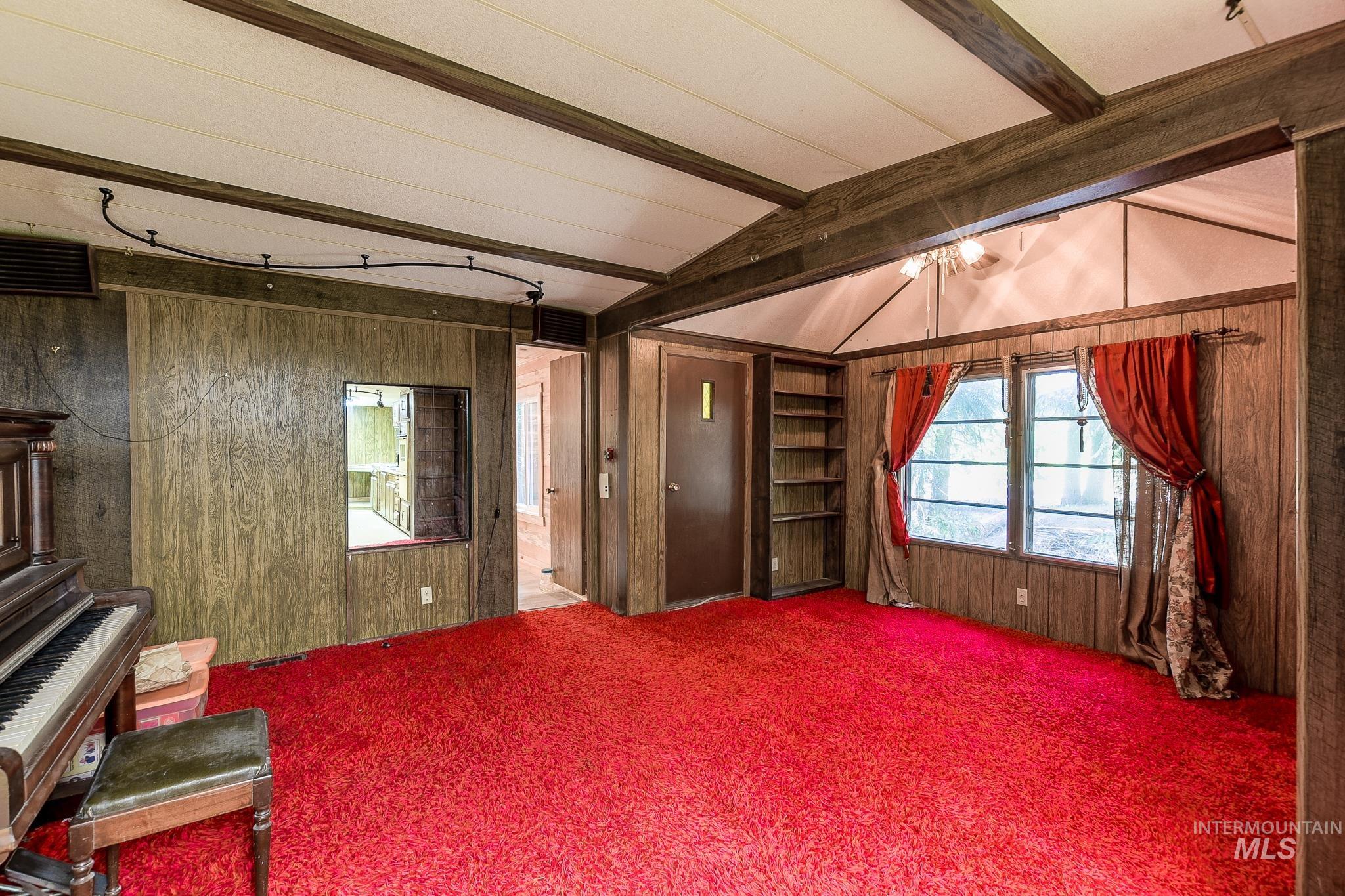 1206 Idlers Rest Road Moscow, ID 83843 - Photo 7 of 47 Interior space featuring wood-finish paneling, exposed ceiling beams, and a red carpet
