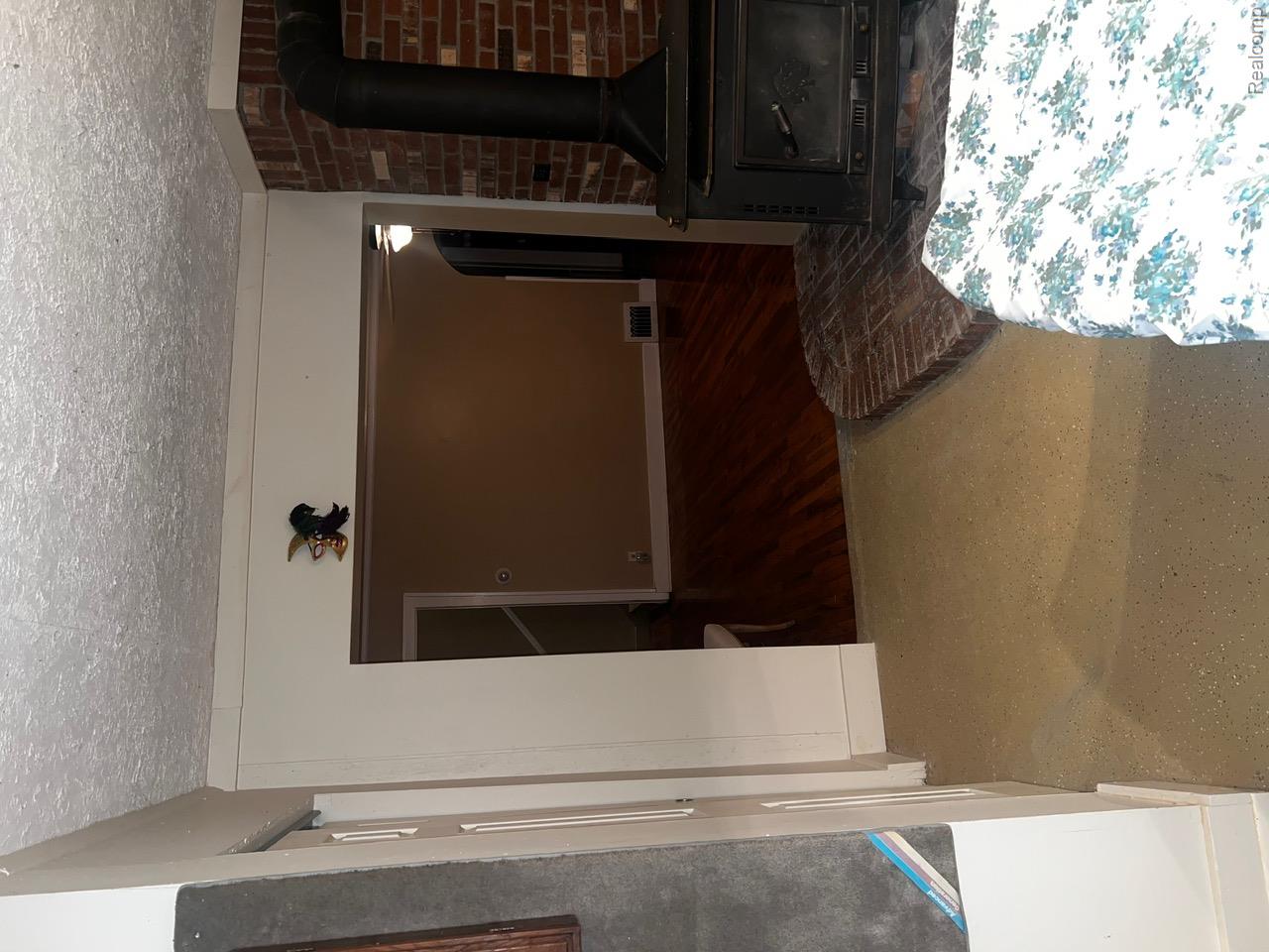 3364 East Pierson Road Flint, MI 48506 - Photo 54 of 67 Bedroom with a wood stove, a textured ceiling, and a closet