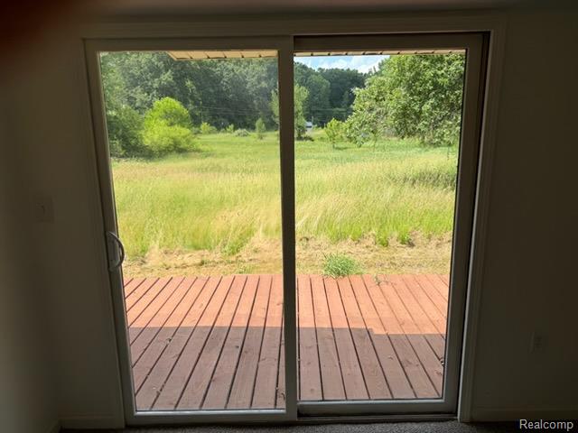 3515 Morton Road Stockbridge, MI 49285 - Photo 25 of 31 Sliding glass door opening to an exterior wood deck overlooking a natural grass field and mature trees
