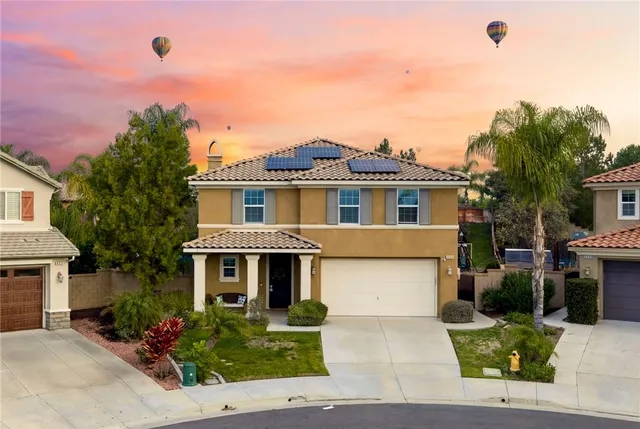 a front view of a house with a yard and potted plants