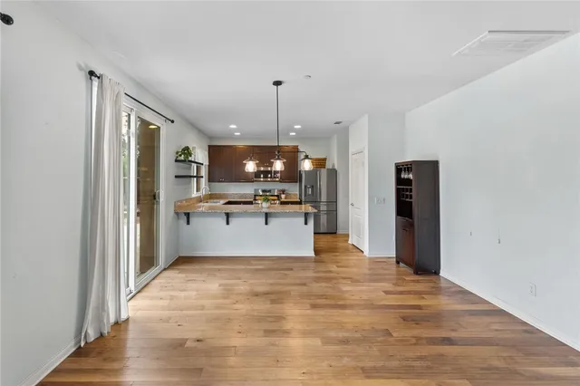 a kitchen with stainless steel appliances kitchen island granite countertop a refrigerator and a stove top oven