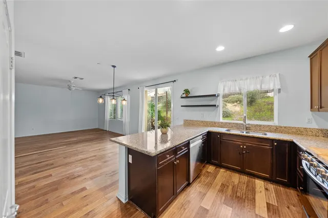a kitchen with stainless steel appliances granite countertop a sink stove and wooden cabinets