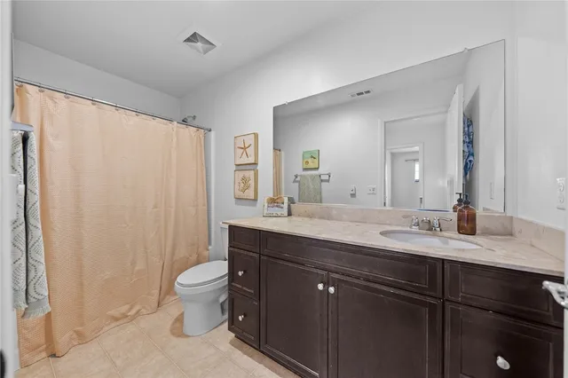 a bathroom with a granite countertop sink toilet a large mirror and a shower