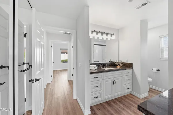 a bathroom with a granite countertop sink and a mirror