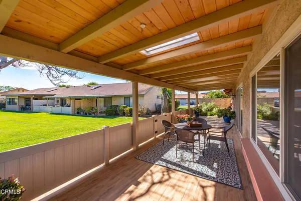 a view of a patio with a table chairs and a backyard
