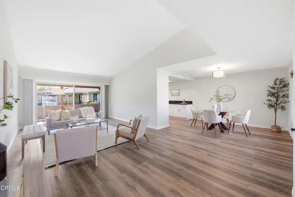 a living room with furniture dining table and a large window