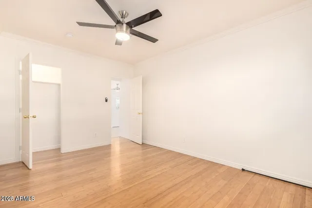 a view of a big room with wooden floor and a ceiling fan