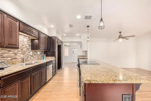 a large kitchen with kitchen island a sink stove and refrigerator