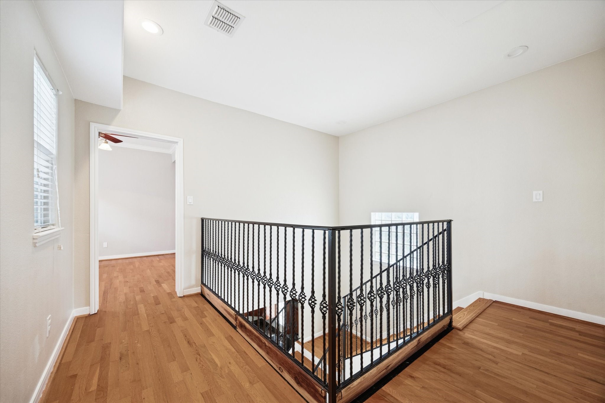 1427 West 25th Street Houston, TX 77008 - Photo 17 of 36 a view of a hallway with wooden floor and a bathroom