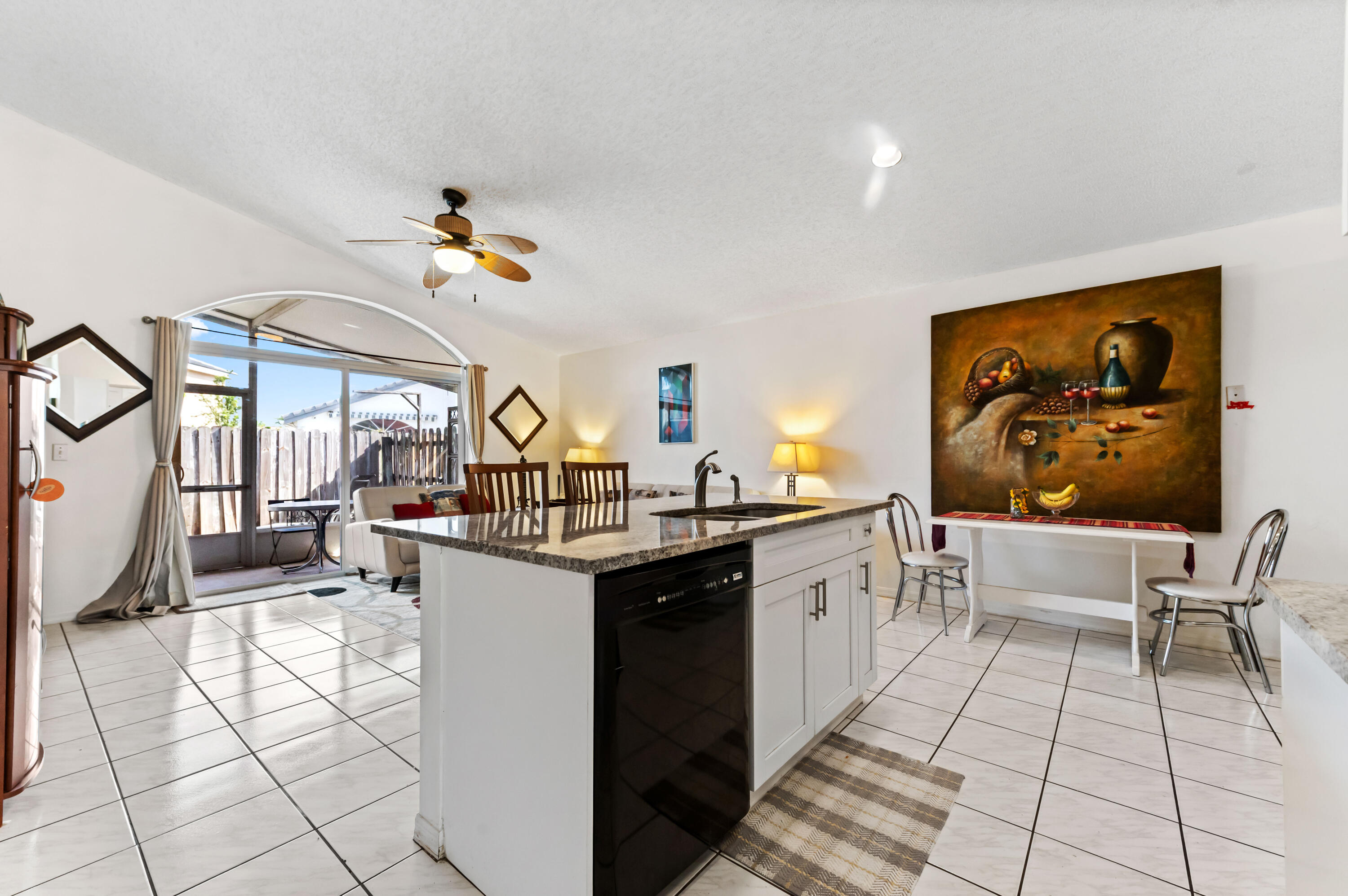 7409 Michigan Isle Road Lake Worth, FL 33467 - Photo 12 of 43 a kitchen with stainless steel appliances a sink a stove top oven a dining table and chairs