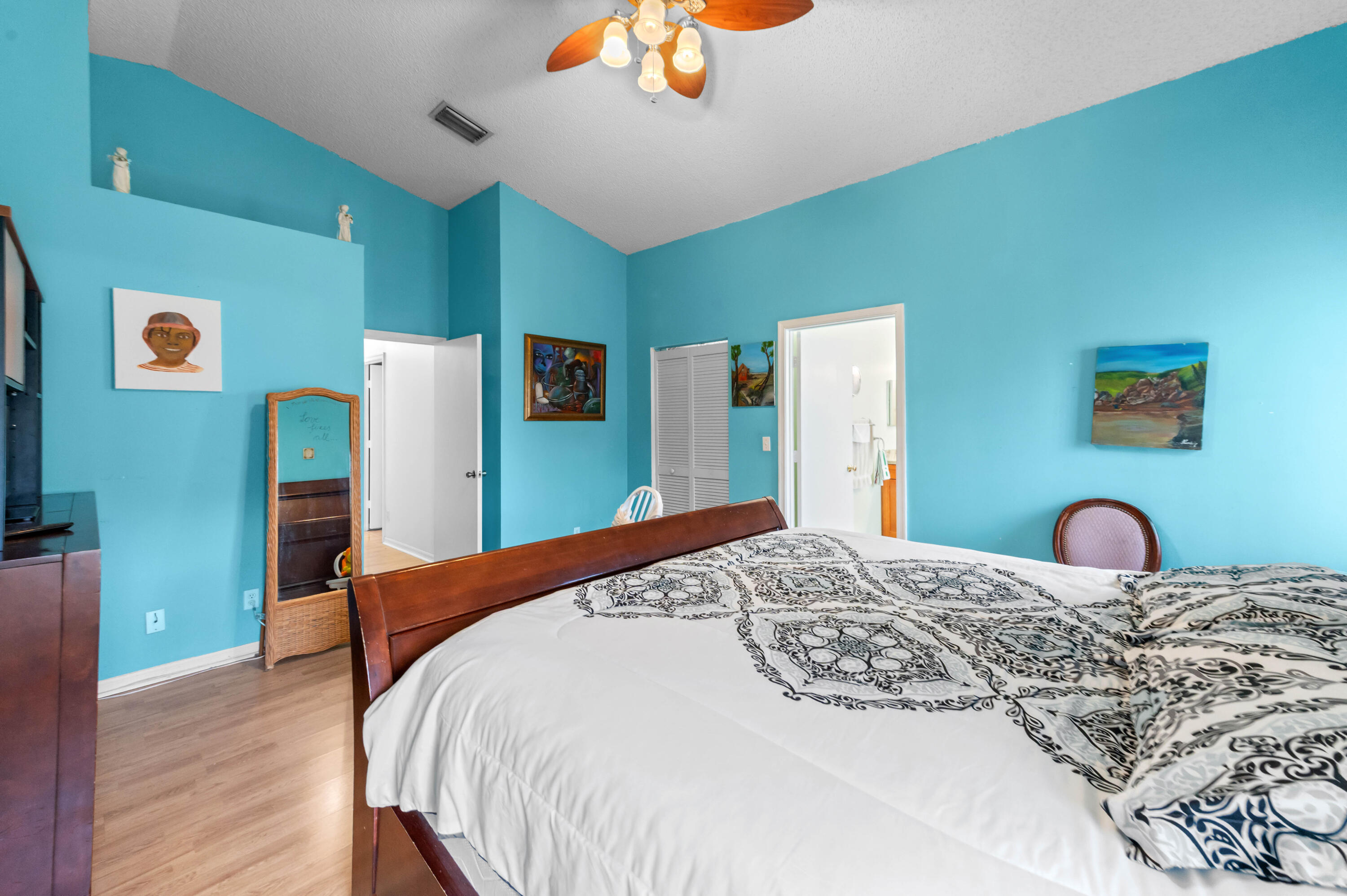 7409 Michigan Isle Road Lake Worth, FL 33467 - Photo 28 of 43 a bedroom with a bed and a chandelier