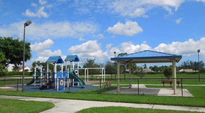 7409 Michigan Isle Road Lake Worth, FL 33467 - Photo 42 of 43 a view of a park with swings a large tree