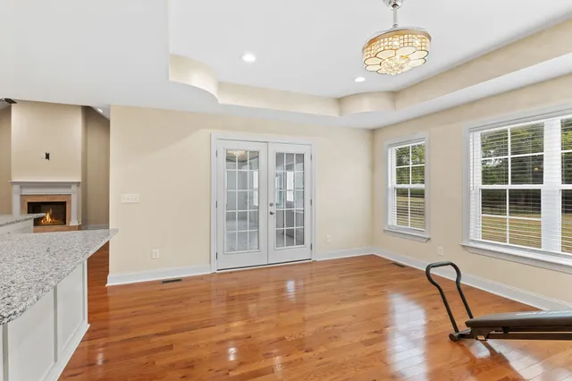 a view of an empty room with a window and kitchen view