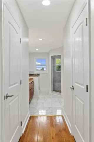 a view of a hallway with wooden floor and closet