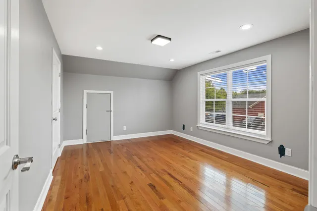 a view of a room with a window and wooden floor