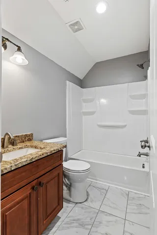 a bathroom with a granite countertop sink a toilet and a mirror