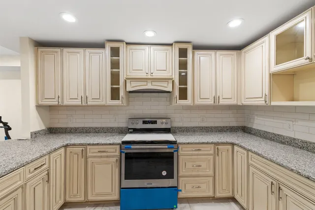 a kitchen with granite countertop white cabinets and appliances