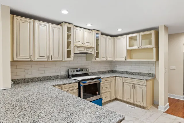 a kitchen with stainless steel appliances granite countertop a stove a sink and a microwave