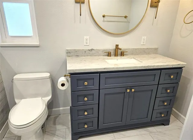 a bathroom with a toilet a sink and mirror