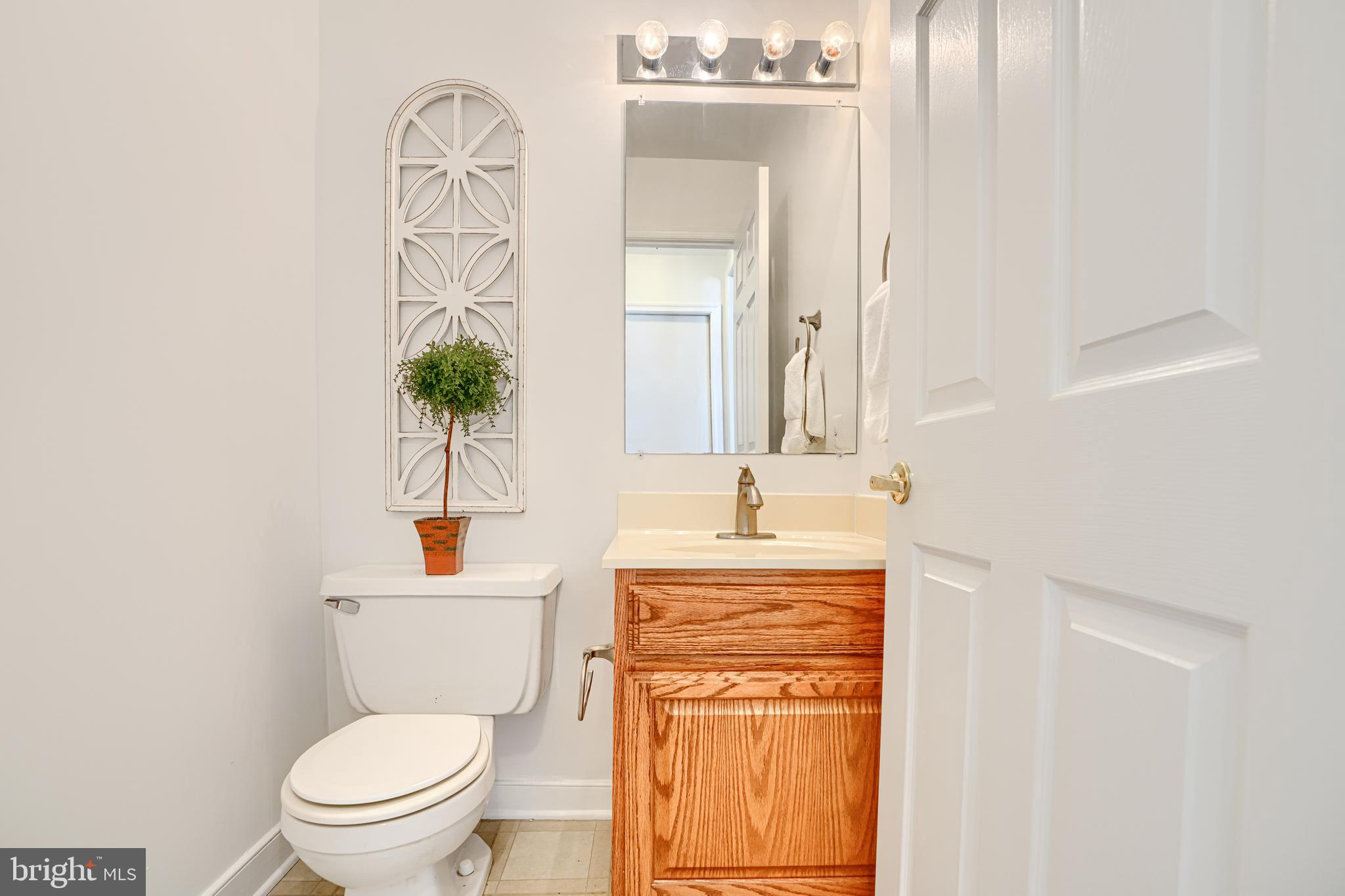 9018 Gardenia Road Baltimore, MD 21236 - Photo 16 of 47 a bath room with a toilet a sink and a mirror