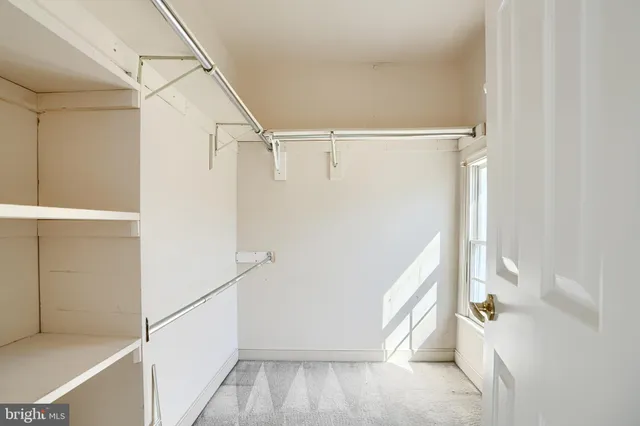 a view of walk in closet with empty racks