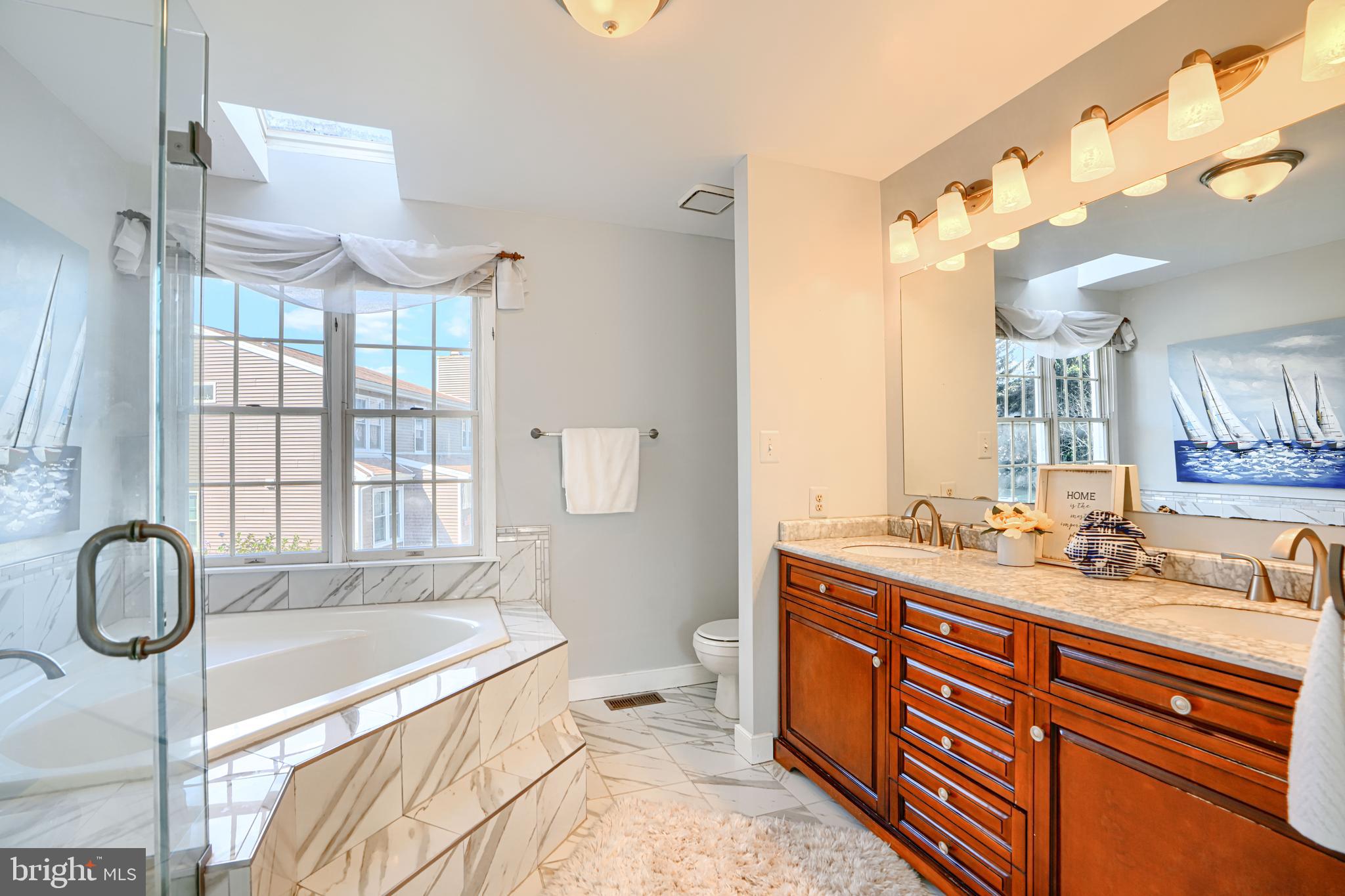 9018 Gardenia Road Baltimore, MD 21236 - Photo 26 of 47 a spacious bathroom with a double vanity sink toilet mirror and bathtub