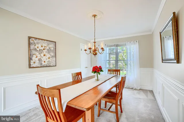 a dining room with furniture a chandelier and window