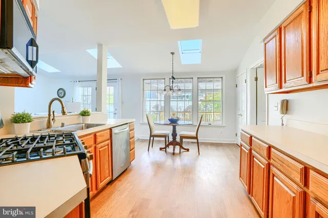 a kitchen with stainless steel appliances granite countertop sink stove and wooden cabinets