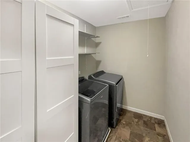 a utility room with cabinets washer and dryer