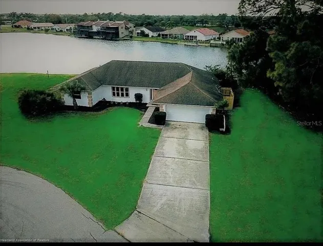 an aerial view of a house with garden space and lake view