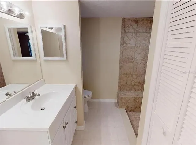 a bathroom with a sink and mirror with toilet