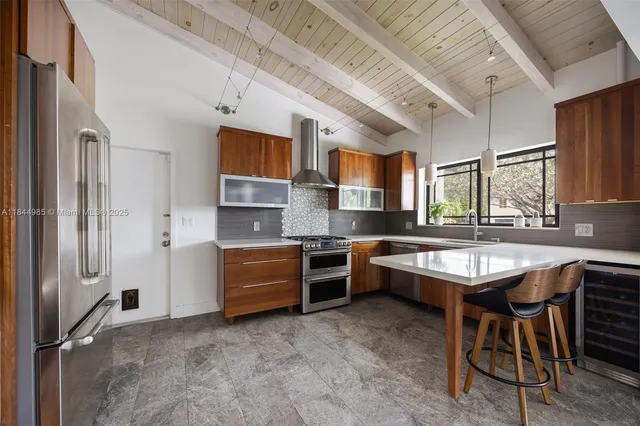 a kitchen with stainless steel appliances granite countertop a stove refrigerator and cabinets