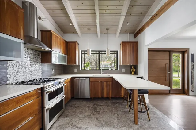 a kitchen with stainless steel appliances granite countertop a stove a sink dishwasher and cabinets with wooden floor