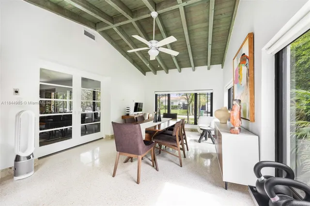 a dining room with furniture water view and a floor to ceiling window