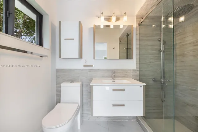 a bathroom with a toilet sink vanity and mirror