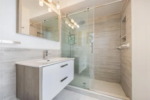 a bathroom with a shower sink and mirror