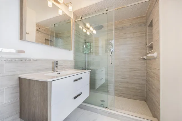 a bathroom with a shower sink and mirror