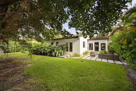 a view of a house with backyard and sitting area