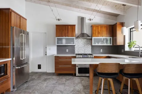 a kitchen with stainless steel appliances granite countertop a stove refrigerator and a sink