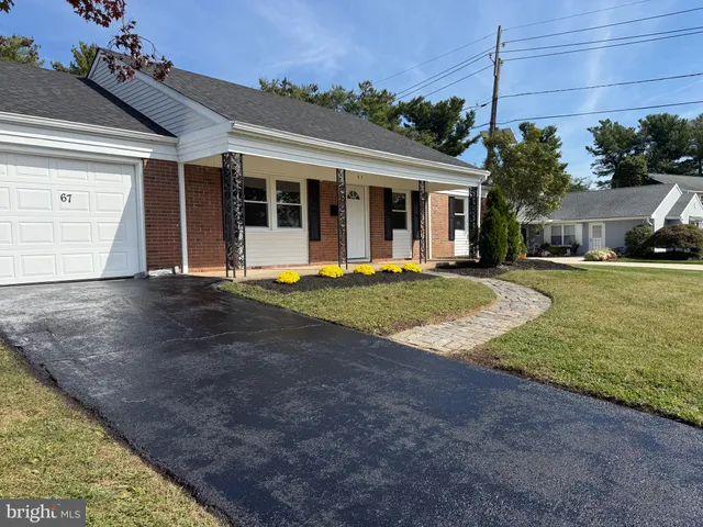 a view of a house with a yard and potted plants