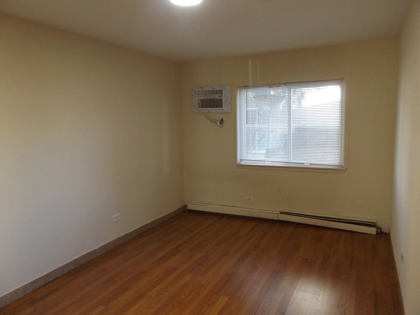 710 West Huntington Commons Road, Unit 1B Mount Prospect, IL 60056 - Photo 8 of 10 an empty room with wooden floor and windows