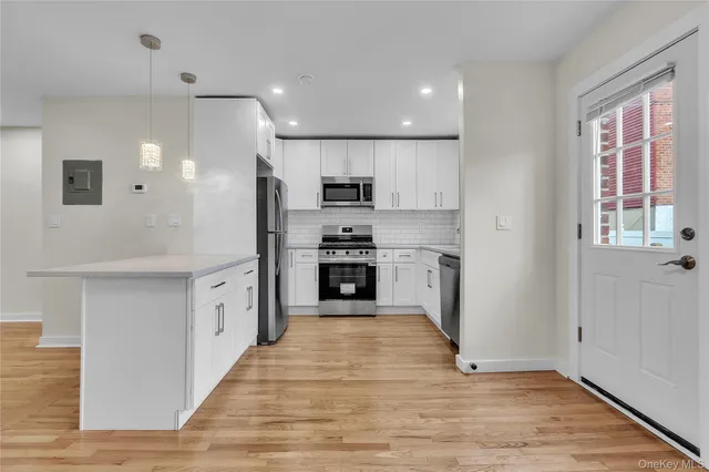 a kitchen with stainless steel appliances kitchen island wooden cabinets and granite counter tops