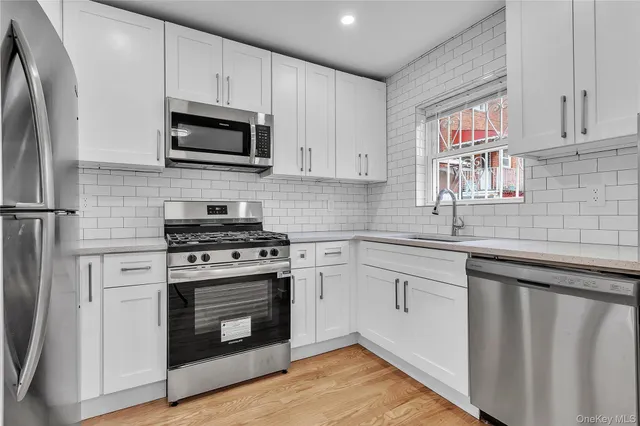 a large kitchen with stainless steel appliances kitchen island granite countertop a stove and a refrigerator